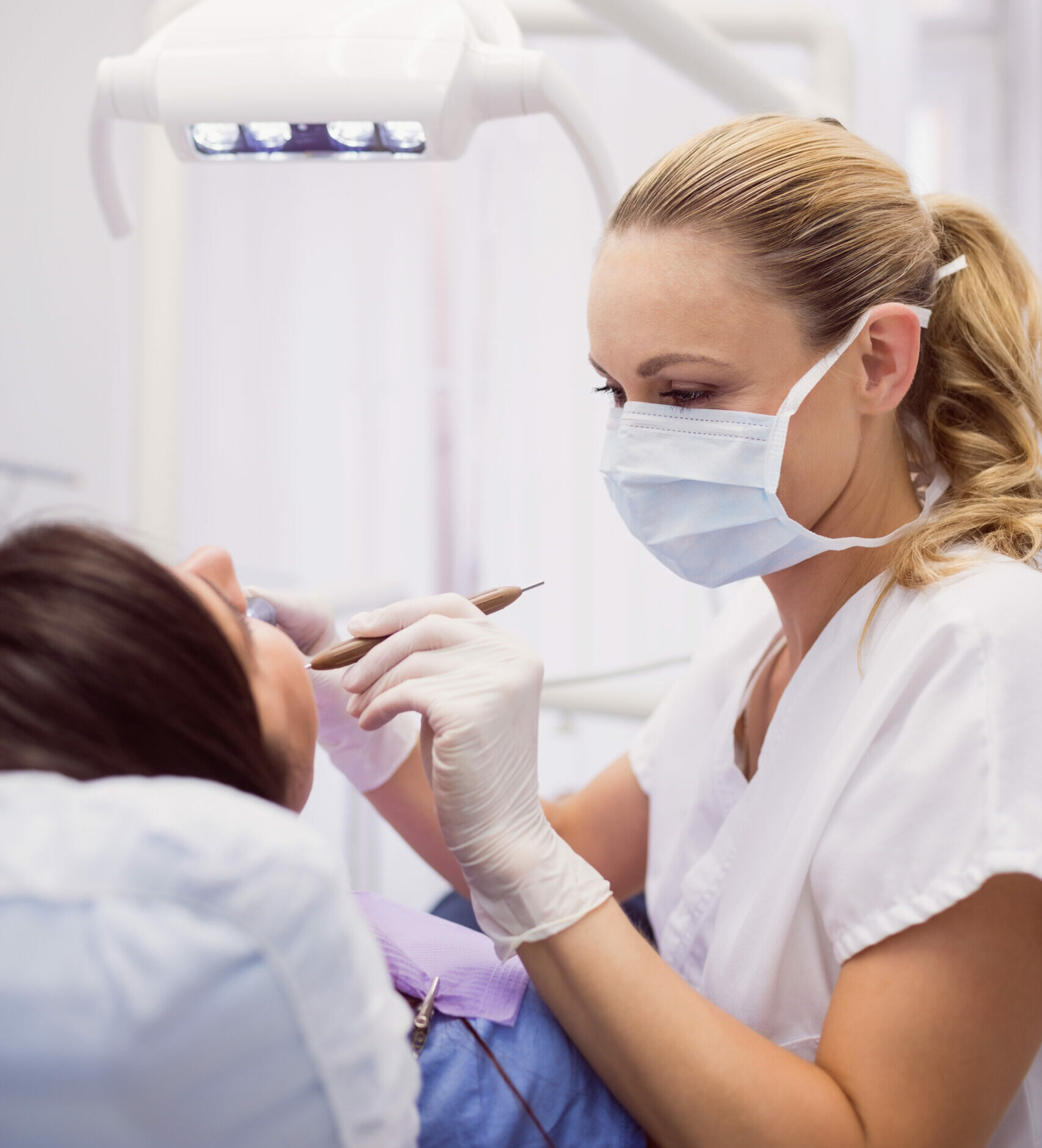 dentist examining female patient in clinic